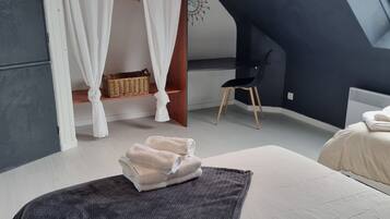 Ein Schlafzimmer mit Bett, Fenster, Stuhl und Wanduhr.