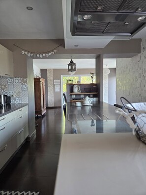 Une cuisine moderne dotée d’un îlot central, de meubles en bois et offrant une vue sur l’extérieur.