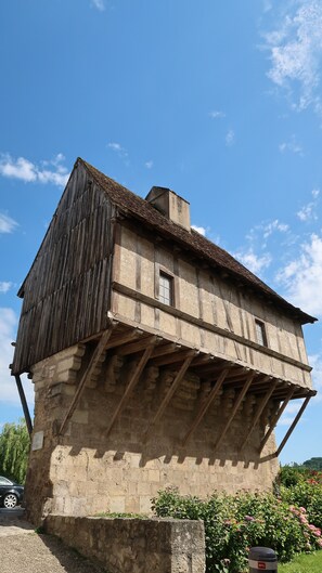 A two-story building with a sloped roof and a stone base.