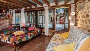 Une chambre rustique avec un lit en bois, un canapé et une vue sur un espace extérieur.