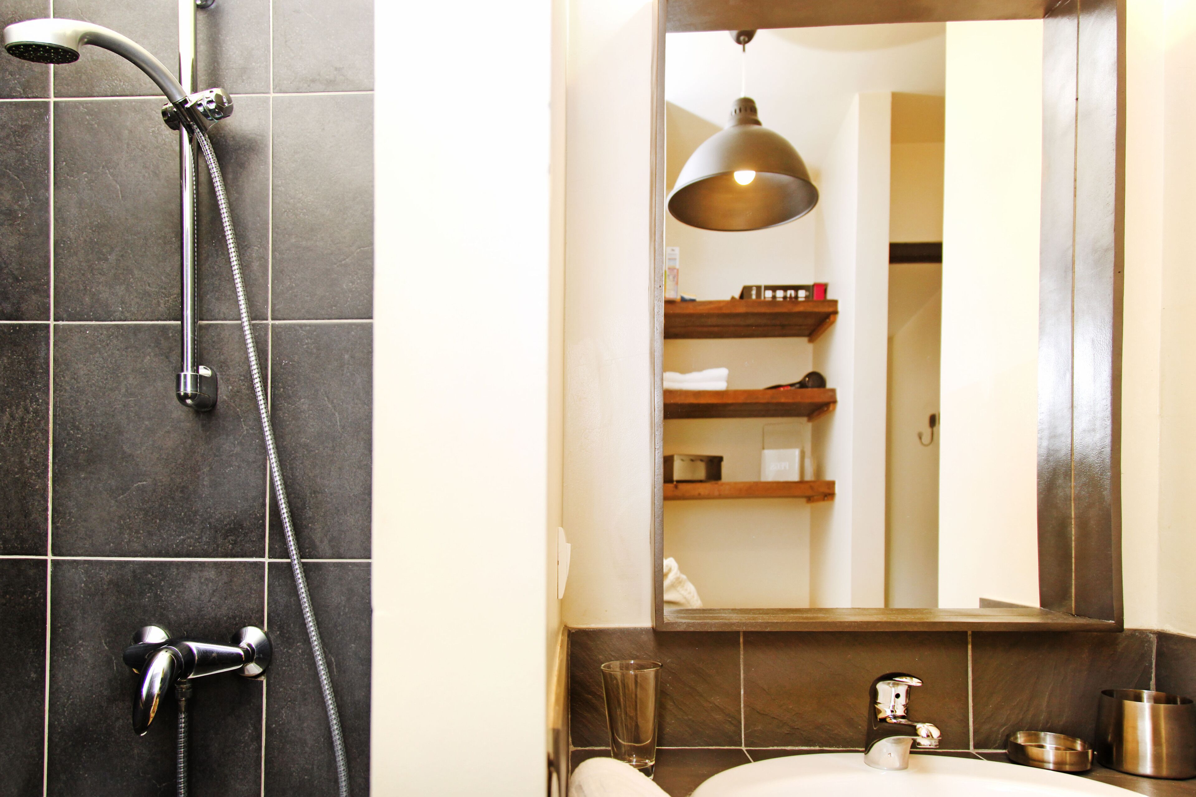 A bathroom with a shower, sink, and mirror.