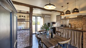 Une cuisine rustique avec une table en bois, des chaises et des lampes suspendues.
