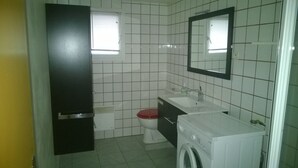 A compact bathroom with a toilet, sink, and washing machine. - AFA villa floor 15 km from Ajaccio (Afa)