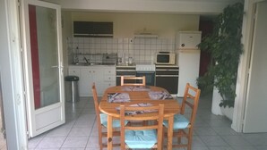 A compact kitchen with white cabinets, a microwave, a stove, and a sink. - AFA villa floor 15 km from Ajaccio (Afa)