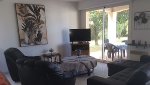 A living room with a sofa, a TV, and a dining area with a table and chairs. - charming holiday home, Bourcefranc le chapus (Bourcefranc-Le-Chapus)