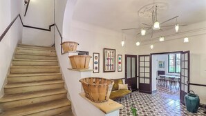 A staircase with wooden steps and a handrail, leading to a room with a patterned floor and a dining area visible through an open door. - 🌿Superb Maison de Maître in Provence with XXL infinity pool and bicycles🌿 (Beaucaire)