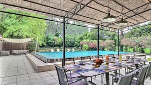 An outdoor dining area with a pool in the background. - 🌿Superb Maison de Maître in Provence with XXL infinity pool and bicycles🌿 (Beaucaire)