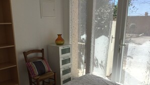 A bedroom with a bed, a chair, a dresser, and a window with a view of the outside. - Vacation rental house with pool CAVAILLON LS2-292 (Cavaillon)