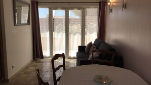 A dining area with a round table, chairs, a sofa, and a sliding glass door leading to a balcony. - Vacation rental house with pool CAVAILLON LS2-292 (Cavaillon)