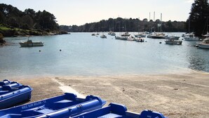 A marina with several boats docked and a sandy beach in the foreground. - cottage swallows (Riec-sur-Bélon)