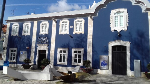Un bâtiment bleu avec l’enseigne « CASA DA BAIA » et une porte noire.