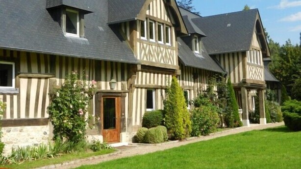 A large, traditional Tudor-style building with multiple gabled roofs and a symmetrical facade.