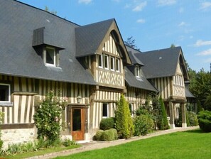 A large, traditional Tudor-style building with multiple gabled roofs and a symmetrical facade.