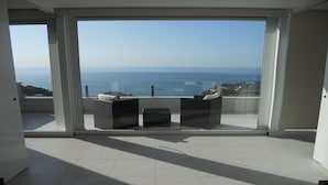 A balcony with a view of the sea, featuring two wicker chairs and a small table. - Architect- villa, heated infinity pool, stunning 360° sea/mountain view, WIFI (Tamariu)