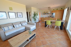 A modern living room with a sofa, coffee table, and a dining area with chairs and a table. - Rental Beautiful Apartment T2 T3 Panoramic Sea View Penthouse In (Calvi)