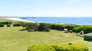 A coastal landscape with a grassy field, a small play area, and a beach in the background. - house direct access to the beach, quiet location exceptional view from the terrace  (Trégunc)