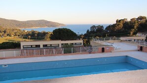 Una piscina en la azotea con vistas al mar y las colinas.