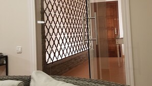 Una sala de estar moderna con un divisor de vidrio, un sofá y una puerta de madera.