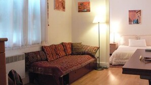 Une pièce confortable avec un canapé, un lit et une petite table.