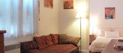 Una habitación acogedora con sofá, cama y una mesita.