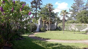 A well-maintained garden with a gravel path, a white fence, and a stone wall. - Family house near Morlaix, enjoy the countryside and the sea (Plouigneau)