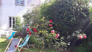 A house with a garden, a blue slide, and a bush with red flowers. - Family house near Morlaix, enjoy the countryside and the sea (Plouigneau)