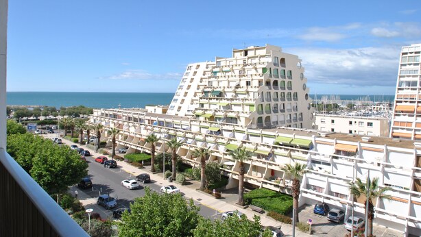 A modern hotel with multiple balconies, a parking area, and a view of the sea. - 2-3 pers air-conditioned studio with harbor and sea view - Grande Motte (La Grande-Motte)
