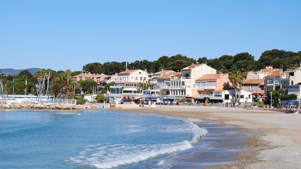 A coastal town with buildings along the beach, a clear sky, and calm sea. - T2 apartment, 40 m2, fully air-conditioned, 350 m from the beach. Private parking (Saint Cyr sur Mer)
