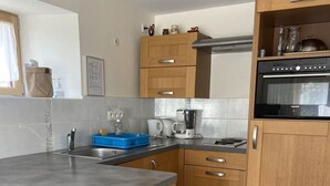 Een moderne keuken met houten kastjes, een inbouwoven en een granieten aanrecht.