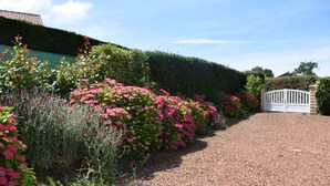 A gravel driveway leading to a white gate, surrounded by well-maintained hedges and flowering plants. - Peaceful retreat with garden, terrace, WiFi & private parking (3 guests) (Wailly-Beaucamp)