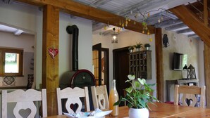 A wooden dining table with a basket of bread, a potted plant, and a bottle of orange juice. - Chalet *** surrounded by nature in the heart of Alsace Calm, comfort and authenticity (Fouchy)