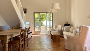 A spacious living area with a dining table, chairs, a sofa, and a coffee table.