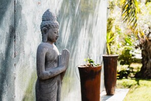 Una estatua de Buda de piedra en un jardín.