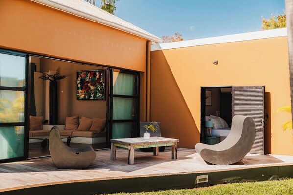 A modern outdoor living area with a sofa, chairs, and a table.