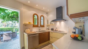 A modern kitchen with a central island, double sinks, and a gas stove.