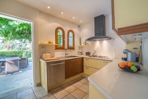 Cozinha moderna com ilha central, duas pias e fogão a gás.