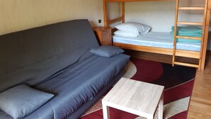 A room with a bunk bed, a sofa, and a small table. - Accommodation 4 people garden, quiet, GERARDMER FREE WIFI (Gérardmer)