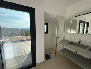 Regadera, secadora de cabello, toallas, papel de baño 