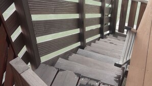 A wooden staircase leading to a beach area with a railing. - Apartment of 190 m2 above the water (La Trinité)