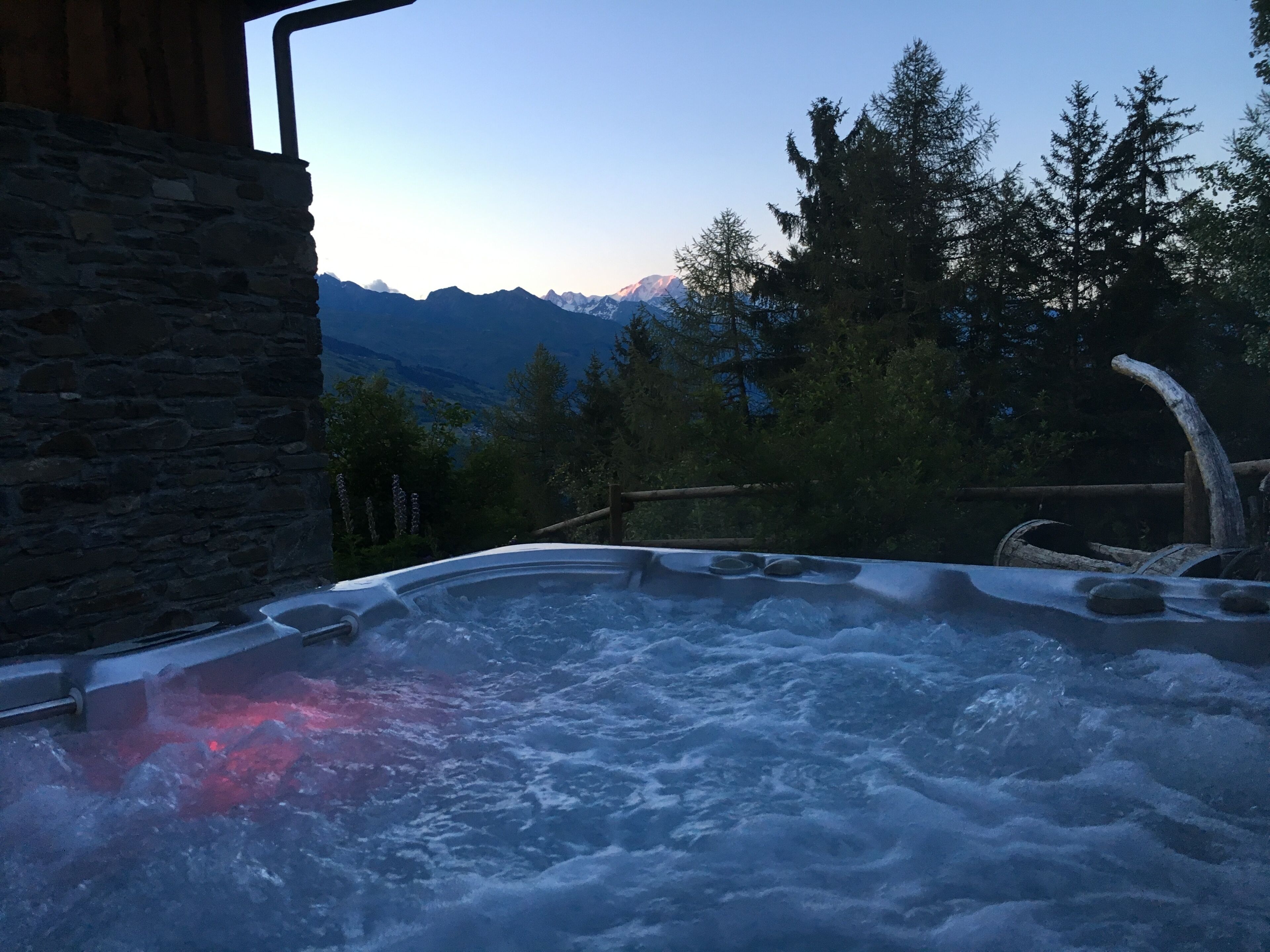 A hot tub with a view of mountains and trees.