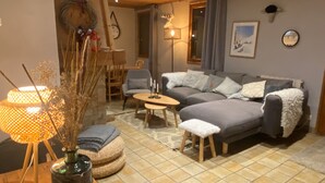 A cozy living room with a sofa, a small table, and a lamp. - Cosy chalet with outdoor spa and sauna facing Mont Blanc - MontchavinLa Plagne (La Plagne Tarentaise)