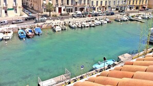 Un port de plaisance avec des bateaux amarrés, un bâtiment portant une enseigne et une vue dégagée sur l’eau.