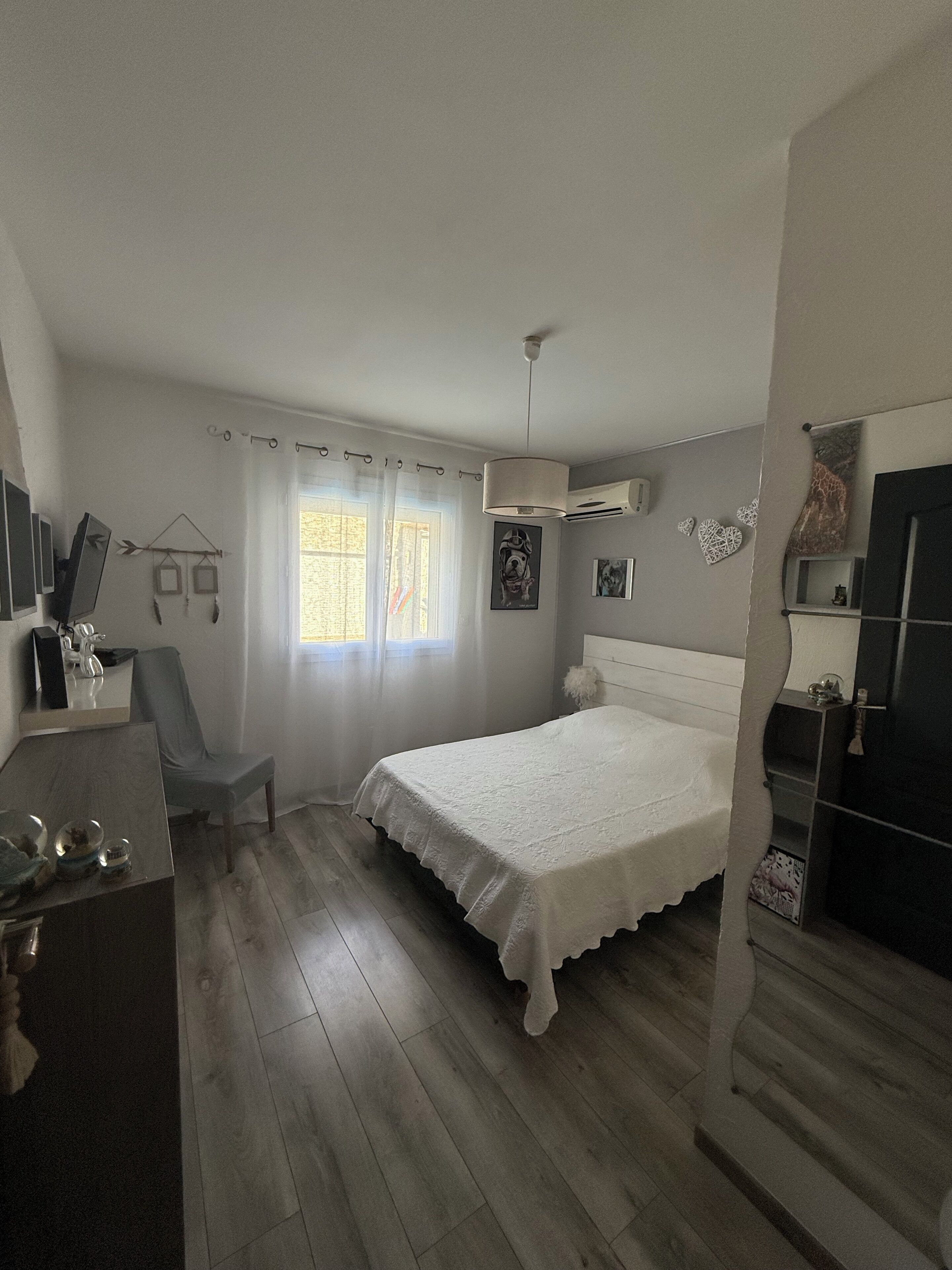 Une chambre à coucher comprenant un lit, une chaise, un bureau et une armoire.