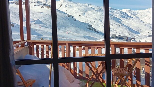 Une pièce dotée d’une grande fenêtre donnant sur un paysage montagneux enneigé.
