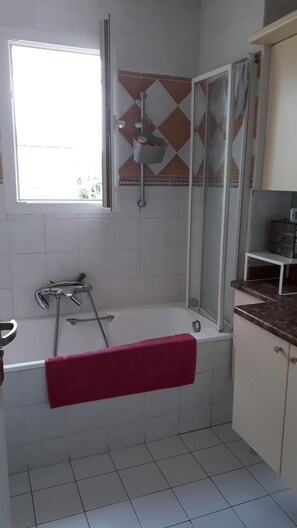 Bathtub, towels, soap, toilet paper