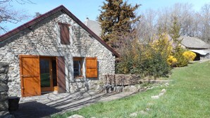 Ein Haus aus Stein mit Holzhörnern, einer Steintreppe und einem Rasen.