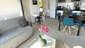 A modern apartment with a living room, dining area, and kitchen. - Apartment T2.40 m2, air-conditioned, 3 terraces, 350 m from the beach. Private parking. (Saint-Cyr-sur-Mer)