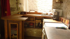 A compact kitchen with a wooden countertop, a sink, and a window providing natural light.