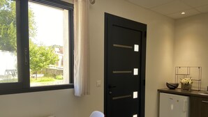 Eine kleine Küche mit einem Kühlschrank, einem Spülbecken und einem Fenster mit Vorhängen.