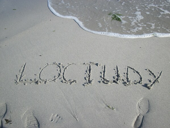 Footprints and the word "LOCTUDY" written in the sand on a beach. - Loctudy: Single storey holiday home 300 m from the beautiful beach of Lodonnec (Loctudy)